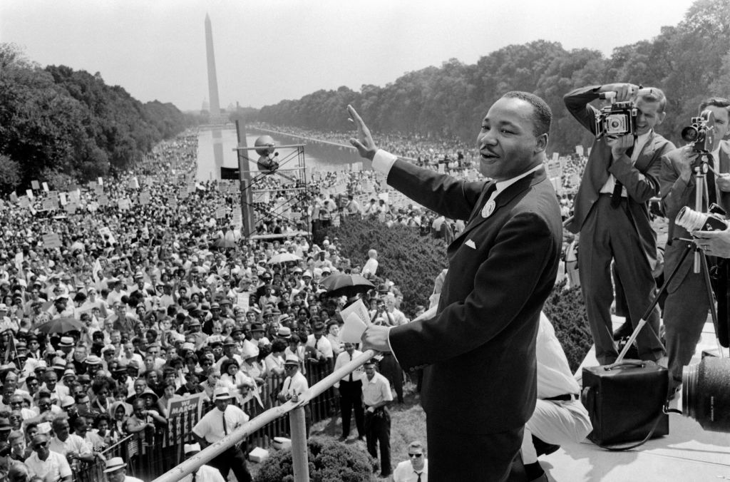MLK smiles and waves at large audience